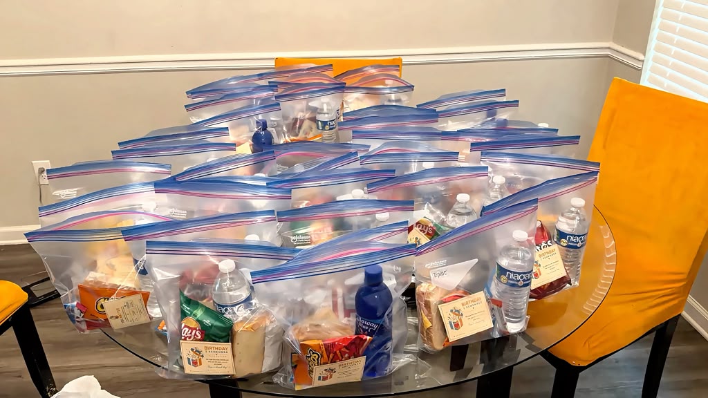 Care packages prepared for community outreach, each bag holding food, water, and a Birthday 2 Remember card.