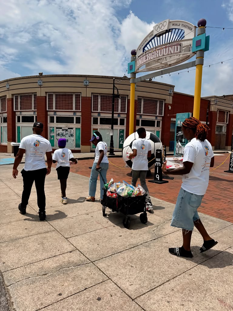 Birthday 2 Remember volunteers in organization shirts walking a wagon of care packages through Underground Atlanta to serve the community.
