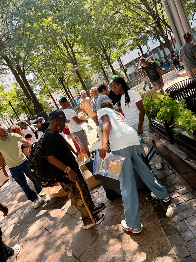 A Birthday 2 Remember volunteer handing a care package to a community member during an outreach in downtown Atlanta.