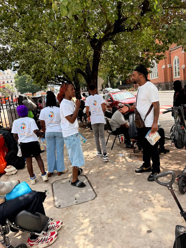 Birthday 2 Remember volunteers talking with community members under the trees while handing out care packages.